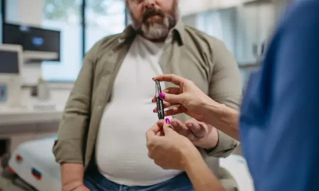 Lekarz mierzy poziom glukozy u pacjenta. Czy przy cukrzycy się chudnie czy tyje? To zależy od typu i leczenia.