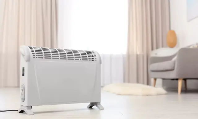 Ein weißer Elektroheizer steht im Wohnzimmer. Er hilft, die strom heizung kosten pro monat im Blick zu behalten.