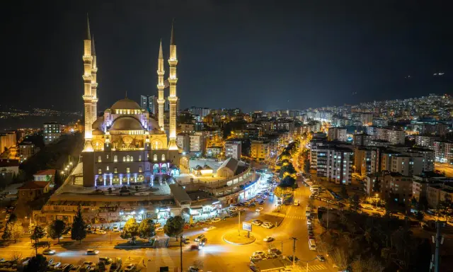 Piękny meczet nocą, oświetlony i otoczony miastem. Warto wiedzieć, ramadan co to za święty czas.