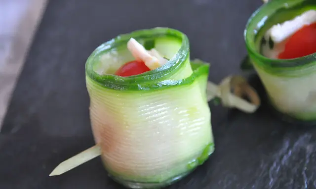 Délicieux wrap apéro de concombre garni de fromage frais, tomate cerise et herbes. Parfait pour un apéritif léger et coloré.