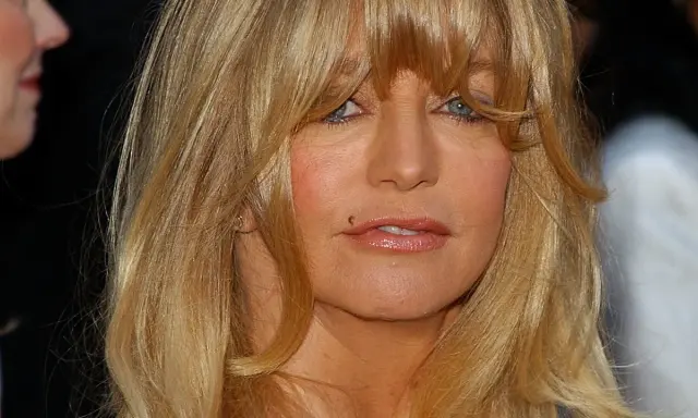 Goldie Hawn ler mot kameran, hennes blonda hår faller runt ansiktet. Tänker på alla roliga filmer med Goldie Hawn.