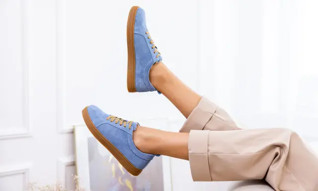 Niebieskie buty z nubuku, jak odnowić je, by wyglądały jak nowe. Stylowe sneakersy na brązowej podeszwie.