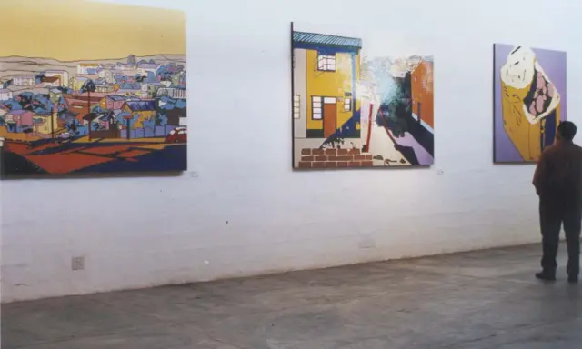 A person contemplates vibrant, stylized paintings in an art gallery, each piece curating meaning through bold colors and urban landscapes.