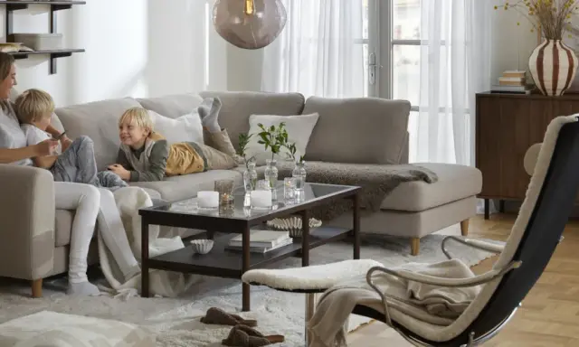 Familj myser i soffan. För att skydda tyget och göra det lättare att rengöra, kan man impregnera soffan.