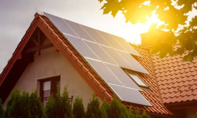 Panele słoneczne na dachu domu łapią promienie słońca, zapewniając czystą energię.