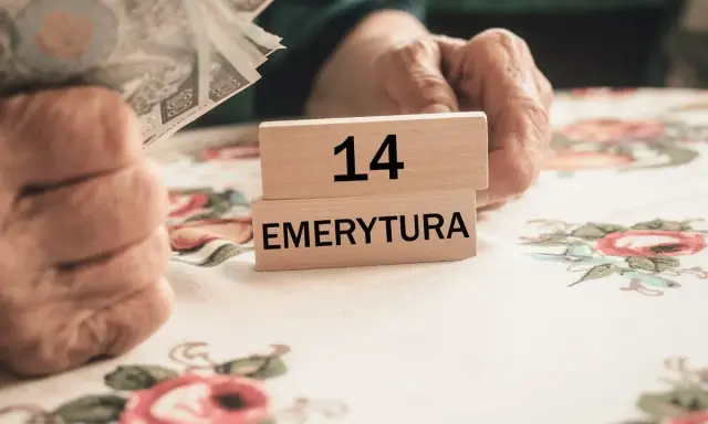 Dłoń trzyma banknoty, obok kostki z napisem "14 EMERYTURA". Zastanawiasz się, ile to brutto, gdy masz 2200 netto?