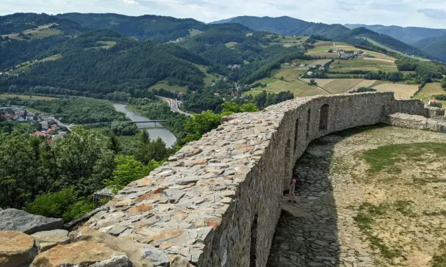 Kamienne mury zamku w Rytrze, z których roztacza się widok na dolinę Dunajca i okoliczne wzgórza. To wspaniałe **rytro atrakcje** dla miłośników historii i przyrody.
