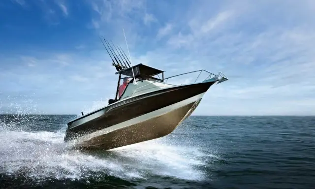 Bateau de pêche rapide sur l'eau, créant des éclaboussures. Le moteur du bateau est puissant, optimisant la consommation.