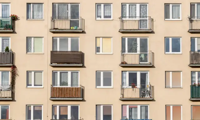 Façade d'immeuble avec de nombreux balcons et fenêtres, offrant un aperçu de la vie quotidienne et du **logement décent**.