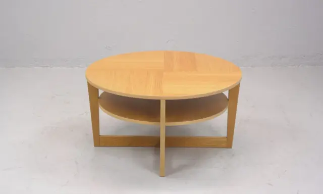 Rundt, ljust träbord med två hyllplan, en klassisk IKEA VEJMON EK. Perfekt för vardagsrummet.