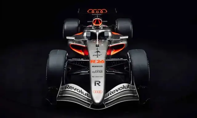 El coche de audi f1, plateado con detalles naranjas y negros, listo para la competición.