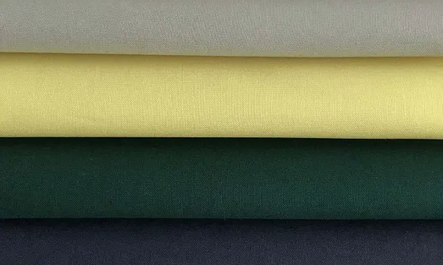 Stacked swatches of poplin fabric in white, light grey, yellow, dark green, and navy blue.