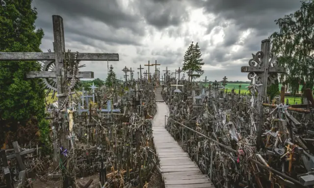 Enorm korskullen i Litauen, fylld med tusentals kors av trä och metall. En stig leder genom den imponerande samlingen.