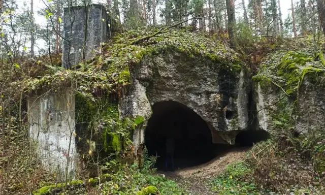 Ruiny twierdzy Osowiec, porośnięte mchem i liśćmi, zapraszają na zwiedzanie. Wejście do bunkra w lesie.