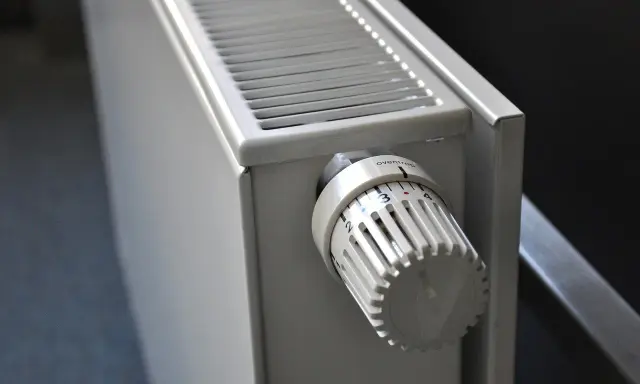 Biały grzejnik aluminiowy z termostatem. Dowiedz się, jak wyczyścić grzejnik aluminiowy w środku, by działał sprawniej.