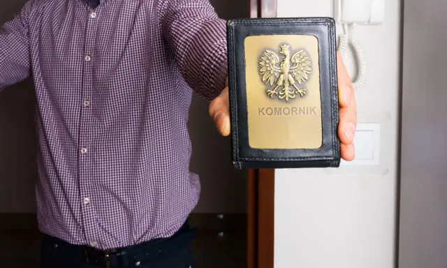 Komornik pokazuje legitymację. Warto znać kwotę wolną od zajęcia komorniczego 2026, by chronić swoje środki.
