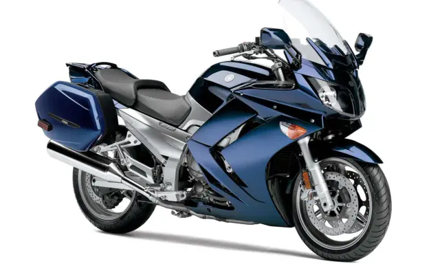 Granatowy motocykl Yamaha FJR 1300, z kuframi. Wady tego modelu to m.in. wysoka cena i waga.