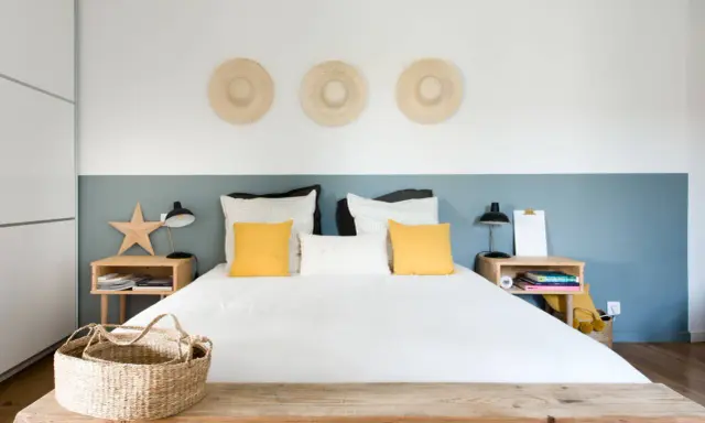 Décoration murale avec trois chapeaux de paille pour comment donner de la hauteur à un plafond bas. Chambre moderne et lumineuse.