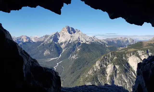 Vista mozzafiato dal **Monte Piana**, con valli profonde, foreste rigogliose e cime maestose sotto un cielo azzurro.