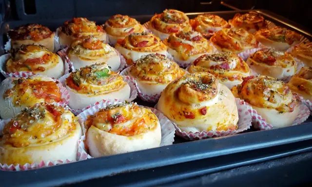 Nybakade pizzabullar med ost och grönsaker, redo för ugnen. Ett perfekt pizzabullar recept för hela familjen.