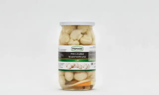 Słoik z marynowanymi pieczarkami marki Figfood, z widocznymi kawałkami warzyw na dnie.
