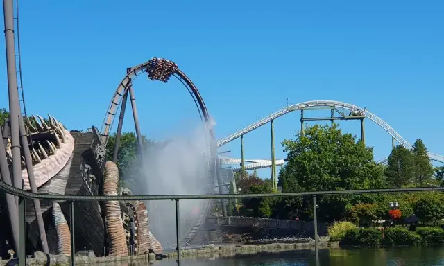 Achterbahn im Heide Park mit Wassereffekt und einem großen Holzmonster.