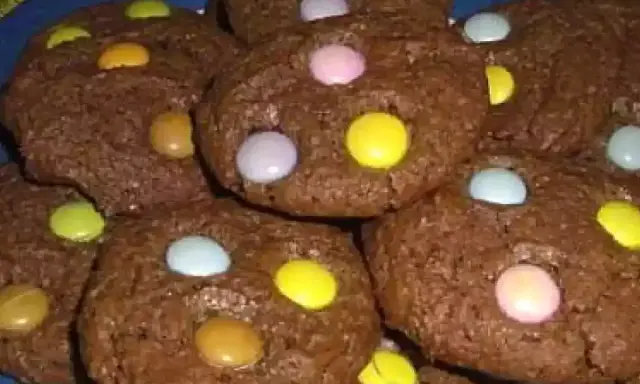 Gros plan sur des cookies chocolat garnis de Smarties colorés. Un délice gourmand pour petits et grands.