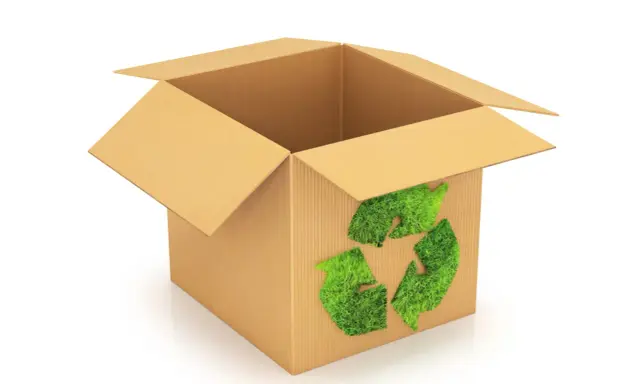 Otwarty karton z zielonym symbolem recyklingu z trawy. To przykład eko opakowania, które dba o naszą planetę.