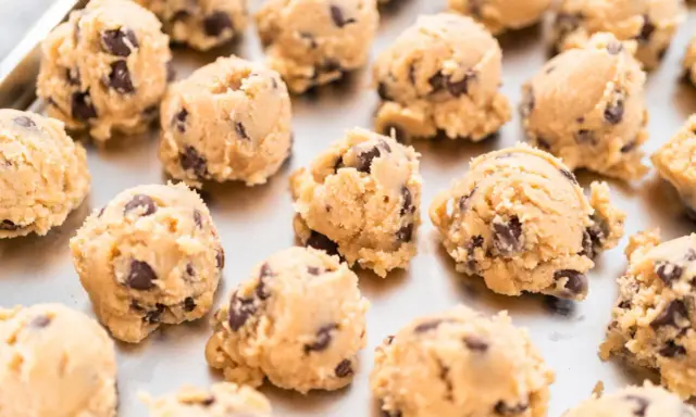 Boules de pâte à cookie au chocolat sur une plaque. Combien de temps la pâte à cookie au frigo se conserve-t-elle ?