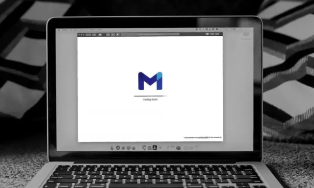 Laptop z otwartym Gmailem, gotowy do wysłania formalnego maila po angielsku.