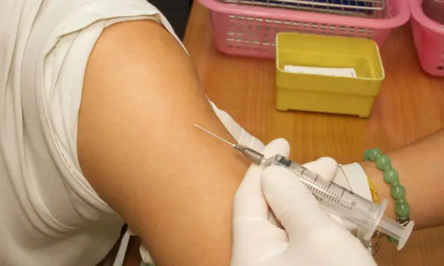 Spritze wird in den Arm einer Person eingeführt, die eine Hyposensibilisierung gegen Asthma erhält.