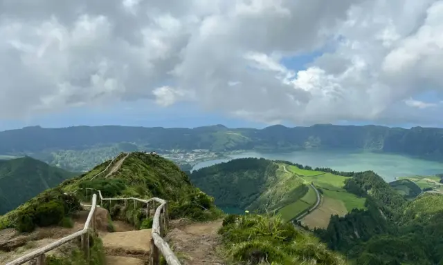 Widok na jezioro Sete Cidades, Azory, Ponta Delgada. Ścieżka z barierkami prowadzi na szczyt z panoramą zielonych wzgórz i wody.