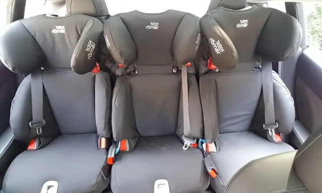 Trzy foteliki Britax Römer na tylnej kanapie. Dowiedz się, jak zamontować fotelik na środku tylnej kanapy, by zapewnić bezpieczeństwo.