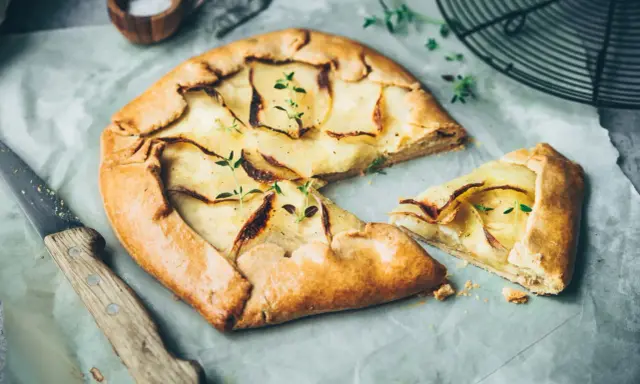 Galette aux pommes, recette de maman, dorée et garnie de fines tranches de pommes, prête à être dégustée.
