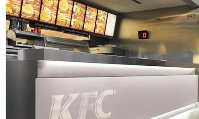 Mostrador de KFC con menú digital y cartel de "0". El food court significado es un área de comida.