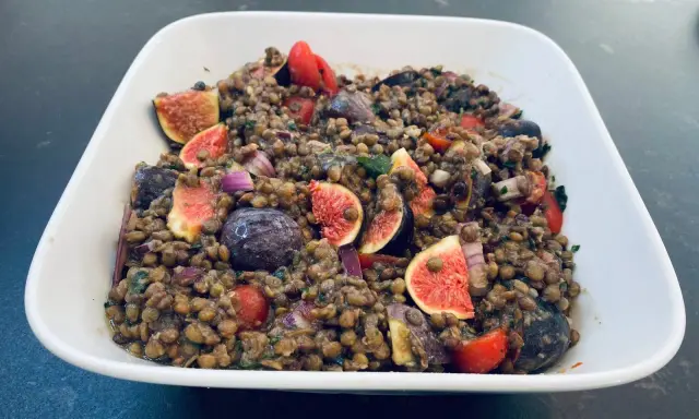 Salade de lentilles aux figues, tomates cerises, olives et oignons rouges. Un plat coloré et savoureux.