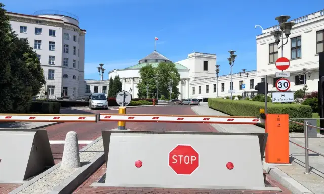 Przed Sejmem RP, gdzie dyskutuje się, ile wynosi dieta poselska, szlaban i znak STOP.