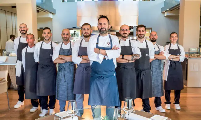 Il team di chef posa con orgoglio, pronto a servire esperienze culinarie d'eccellenza nei ristoranti stellati di Rimini.