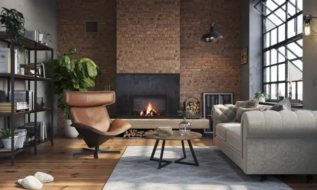 Przytulny salon w stylu loft. Ceglana ściana, kominek, skórzany fotel i wygodna kanapa – idealne salon loft inspiracje.