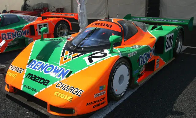 El icónico Mazda 787B, con su distintivo diseño naranja y verde, listo para la carrera.