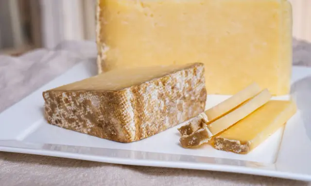 Tranches de Cantal, une des spécialités du Cantal, sur une assiette blanche.