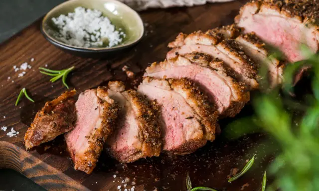Saftige entenbrust im airfryer, perfekt geschnitten, mit grobem Salz und Rosmarin garniert.