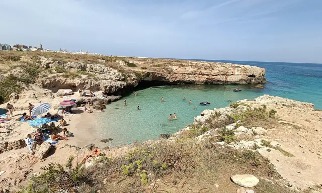 Una splendida giornata alla spiaggia di Porto Verde, con bagnanti che si godono il sole e le acque cristalline.