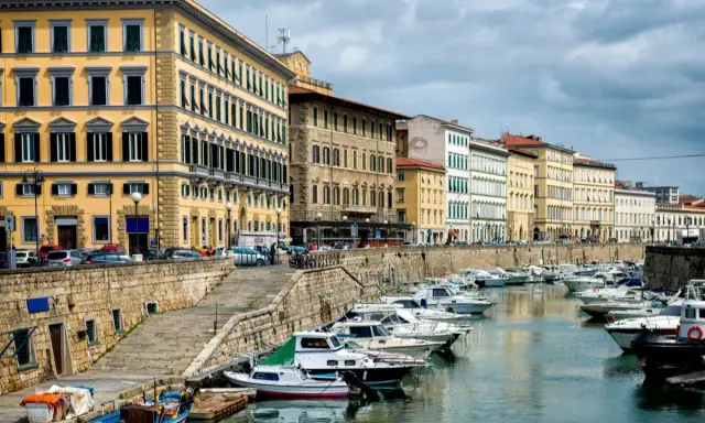 Edifici storici e barche ormeggiate lungo il canale del **terminal crociere Livorno**.