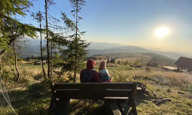 Para siedzi na ławce, podziwiając widok na Beskid Wyspowy. To z pewnością najładniejszy szlak na Mogielicę, z tak pięknym zachodem słońca.