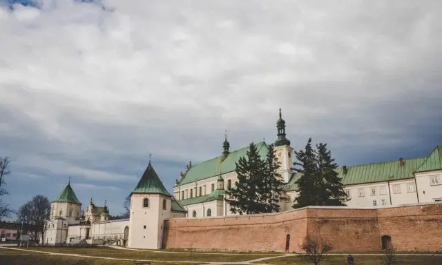 Klasztor Bernardynów w Leżajsku, jedna z głównych atrakcji miasta, z zielonymi dachami i ceglanym murem.