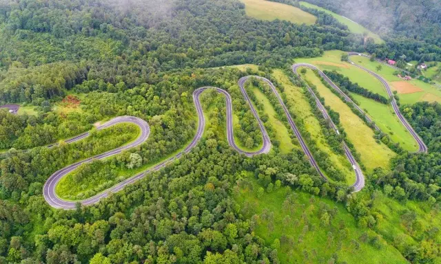 W serpentynach dróg w górach sanocko-turczańskich, wśród bujnej zieleni lasów i łąk, podróżują samochody.