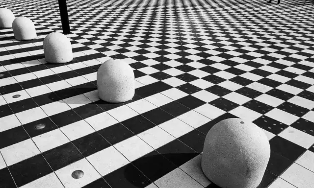 Massi ovali su pavimento a scacchi, un gioco di prospettiva e ombre. #streetphotography