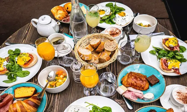 Un festin matinal parisien : œufs Bénédicte, croissants, jus d'orange et café. Un plat typique de Paris pour bien commencer la journée.