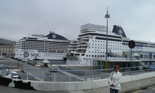 Donna in piedi davanti a due navi MSC in attesa dell'imbarco a Genova per Portofino.
